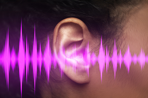 Close-up view of black female ear and sound waveform.