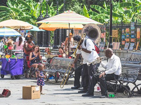 New Orleans, Louisiana, USA, August 26, 2017: the street is busy in New Orleans with people shopping local artists, getting their hair done, and listening to local street musicians.