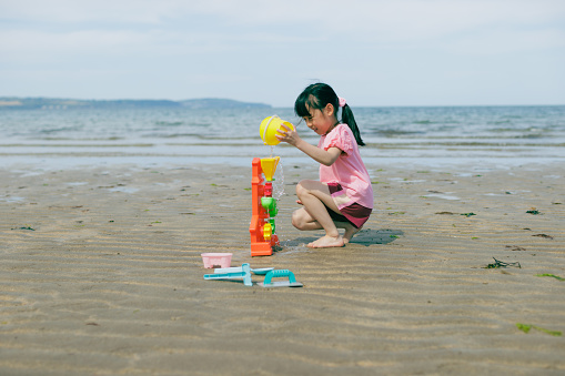 full body view of Young Asian girl was playing on the summer beach