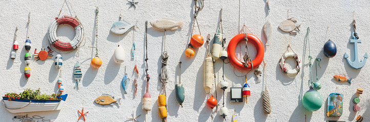 Nautical themed fishing gear, artifacts and decoration from the sea on a white wash pebbledash wall in the coastal seaside fishing village of Lower Largo, Fife, Scotland, UK.