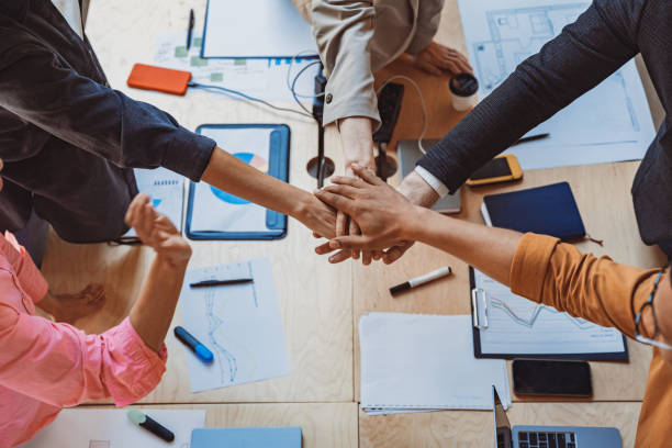 istock Group of coworkers stacking hands together one by one in unity. Support and motivation concept 1501921295