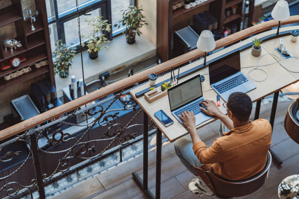 istock Back view of man freelancer working on laptop while sitting in modern coworking 1501922033