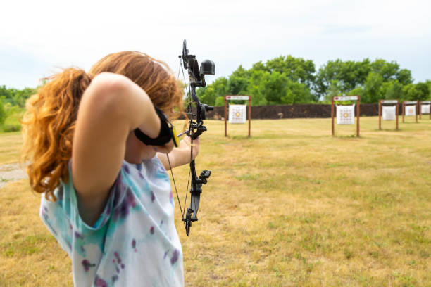 Girl Practicing at Outdoor Archery Range stock photo