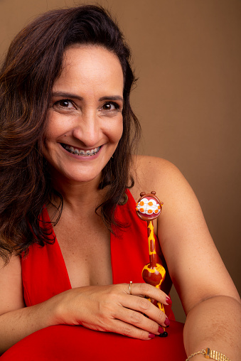Cheerful coaching woman with a giraffe puppet. Symbol of non-violent communication. Isolated on brown background.