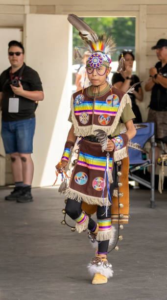 un giovane indigeno che mostra di talenti indossando un panno tradizionale bianco. giornata nazionale della famiglia indigena e pow wow. settimana della consapevolezza aborigena. - first nations dancing aboriginal pow wow foto e immagini stock