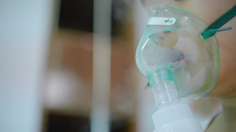 Close-up of Little boy having medicine inhalation with a nebulizer mask in the hospital.