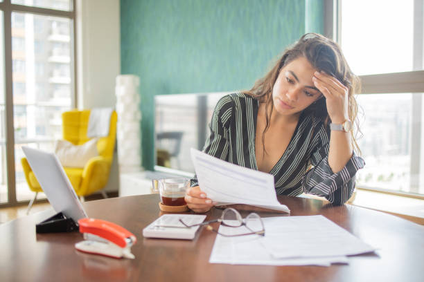 istock Young woman using calculator while going through bills and home finances 1501976857