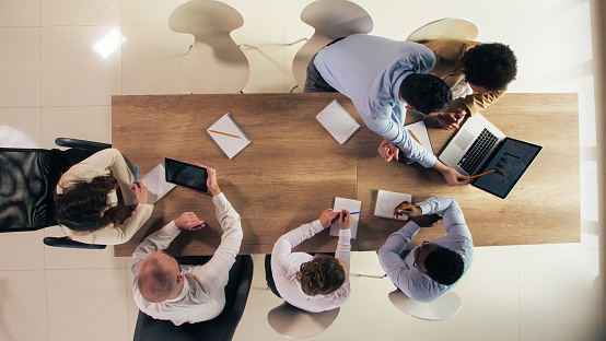 Business team discussing milestones and challenges, directly above view.