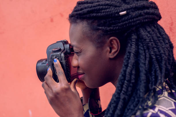 istock Portrait of an woman with dreadlocks smiling while making a photograph with reflex camera. 1501984821