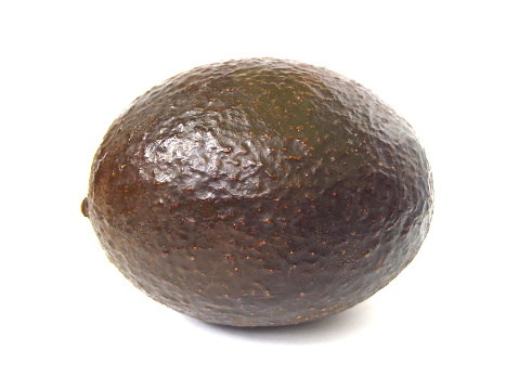 Close up of brown peel avocado isolated on white background.