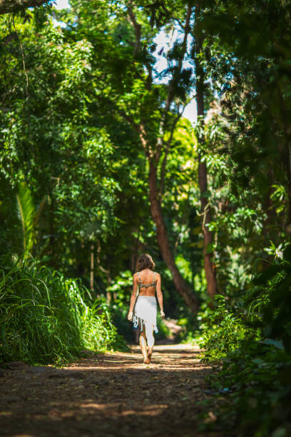 istock Beautiful young woman walking down footpath through tropical rainforest in summer 1502005608