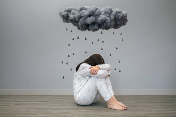 istock Woman with mental disorder and suicidal thoughts crying under a dark storm cloud and raindrops 1502010614
