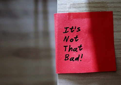 Red sticky note with text written IT'S NOT THAT BAD  - concept of self reminder or a cheer up note to think positively and look at the bright side