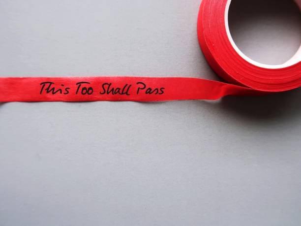 istock Red tape on gray copy space background with handwritten text THIS TOO SHALL PASS, to remind self that nothing, no matter good or bad wonderful or horrible, lasts forever - current situation or feeling will pass 1502074109