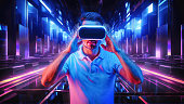 A Caucasian man wearing VR headset and immerses himself in a surreal, futuristic metaverse, where an abstract geometric city unfolds in a kaleidoscope of vibrant neon colors