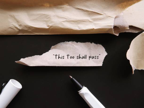 istock Torn office envelope with handwritten text THIS TOO SHALL PASS, self reminder mantra that nothing, good or bad, lasts forever; all circumstances are temporary 1502096351