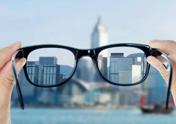 eye glasses looking to cityscape - transparent holding glass focus on foreground imagens e fotografias de stock