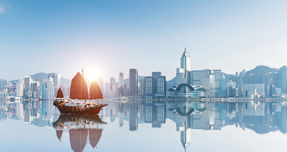 Red junk boat crossing Hong Kong harbor