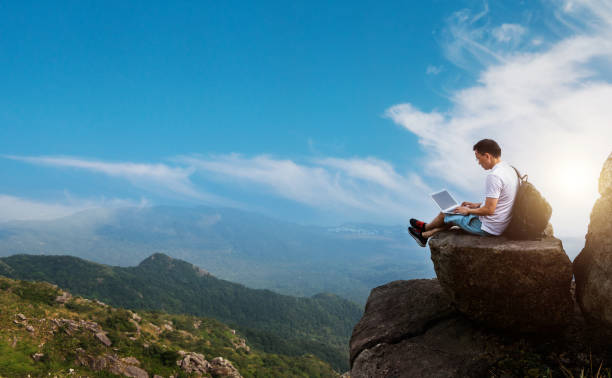 istock Man using laptop at the edge of a cliff 1502101879
