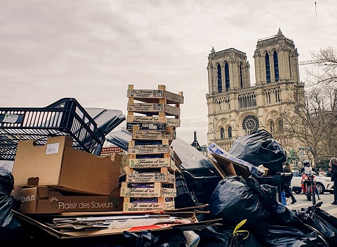 Paris, France – March 30, 2023: A pile of trash with the Notre Dame de Paris in the background in France