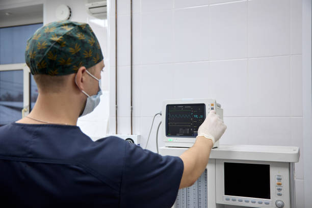 istock Man in a medical uniform turns on a device for anesthesia during surgery 1502109474
