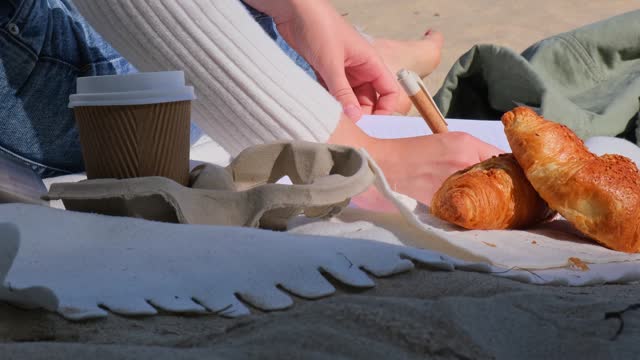 Young student study with notebook on beach next to sea ocean view. Writing gratitude journal self reflection self discovery self discovery, journal, self reflection, creative writing, self growth, personal developmentDrinking coffee and eat croissants. O