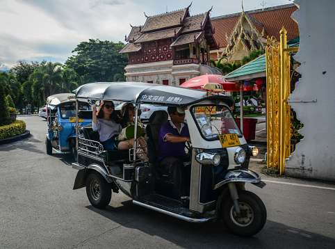 Chiang Mai, Thailand - Jun 22, 2016. Tuk tuk taxis run on street in Chiang Mai, Thailand. Chiang Mai (Chiengmai) is the largest city in Northern Thailand.