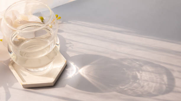 istock Glass cup on table with reflection of sun rays 1502130600