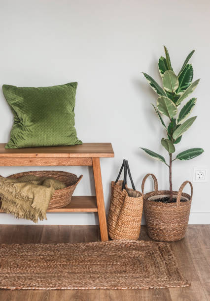 istock Cozy interior in Scandinavian rustic style - an oak bench with a pillow, a basket with blankets, a ficus in a basket. minimalistic style 1502134716