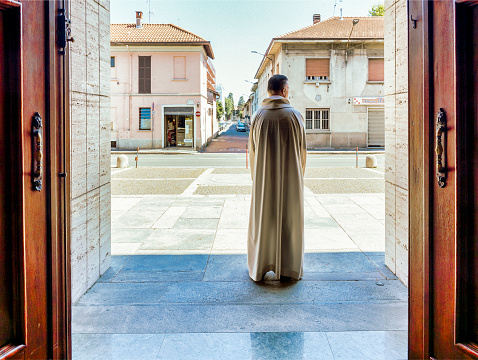 Legnano, Italy - June 25, 2023: pastor awaits the faithful for mass in the churchyard