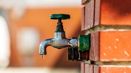 Water supply, outdoor garden faucet with green handle, selective focus