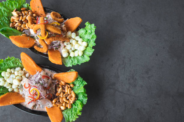 Peruvian eviction with fresh fish, seafood, on rustic stone background from above, traditional dish of Peruvian cuisine with space for text