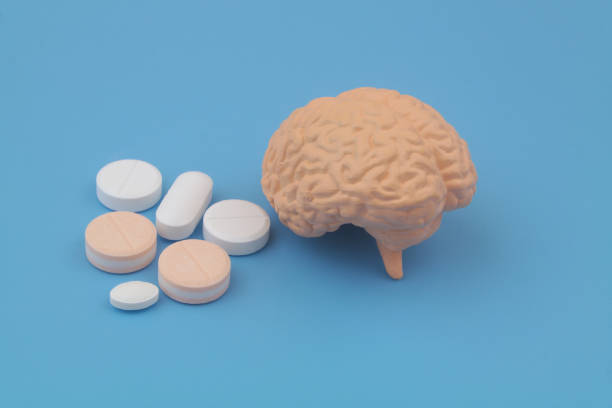 istock Human brain model and medical pills on blue background. 1502148721