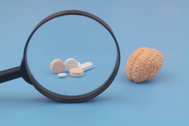 istock Human brain and drugs under magnifying glass. 1502148803