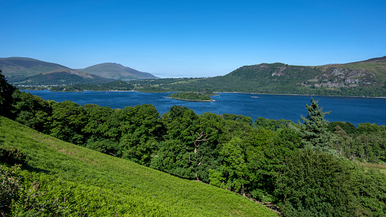 Scenic Lake District landscape with lake, green mountains, meadows and ferns