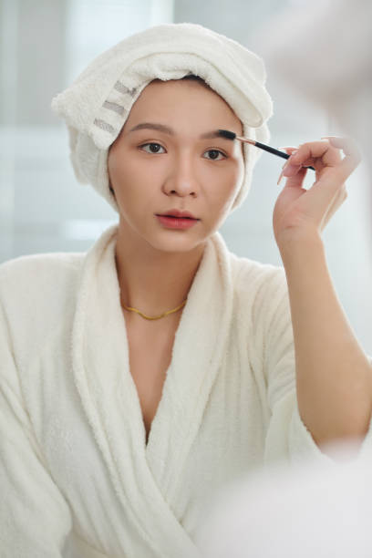 istock Transgender Woman Brushing Eyebrows 1502152759