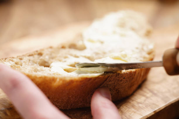 istock young female hands spreading butter on bread 1502160037