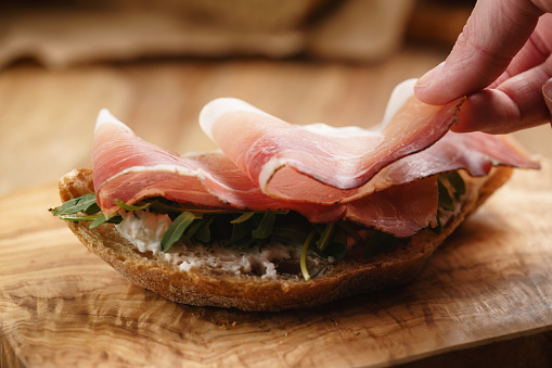 italian sandwich with speck and arugula salad, shallow focus