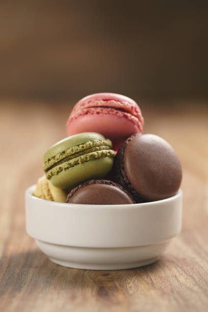 istock assorted macarons in white bowl on wooden table 1502166752