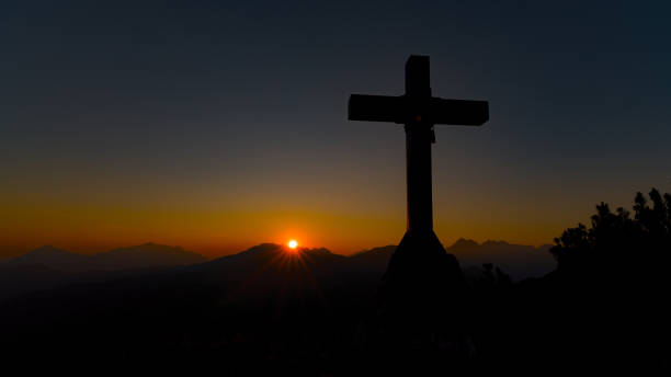 istock Top of a mountain with a cross in the setting sun 1502172361