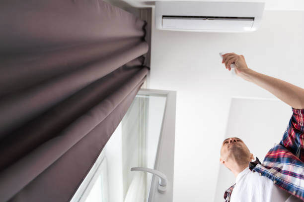 istock Young Happy man Holding Remote Control Air Conditioner In House 1502186374