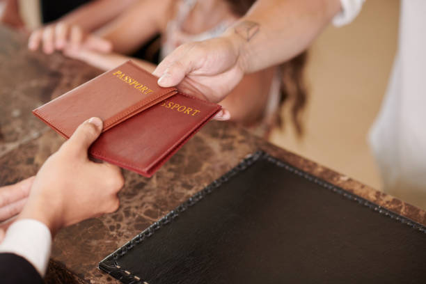 istock Guests Giving Passports to Hotel Receptionist 1502190586