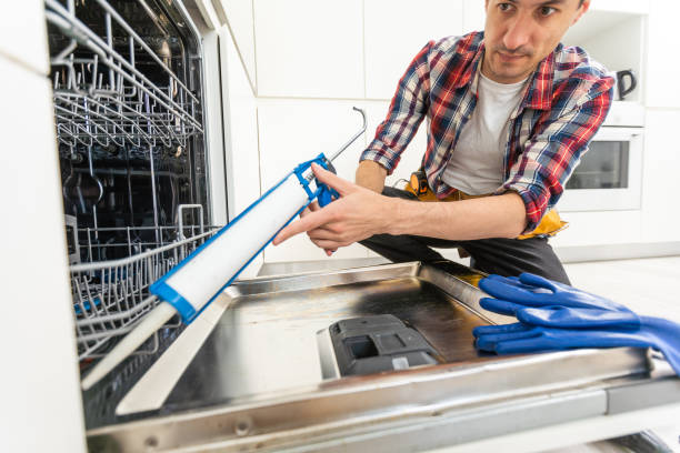 istock Repairman examining dishwasher with toolbox in kitchen 1502193820