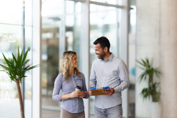 istock Happy business colleagues talking in a hallway. 1502205267