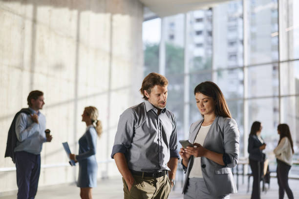 istock Business colleagues using mobile phone in a hallway. 1502205843