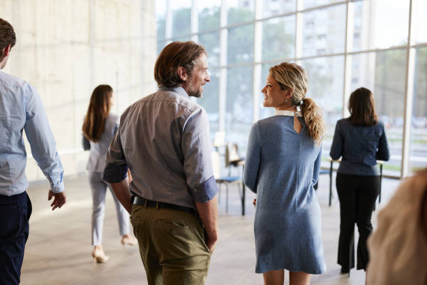 istock Back view of happy business colleagues talking on the move. 1502206876
