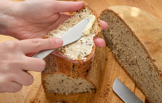 Making sandwiches, butter on a kitchen knife, spread on bread, fresh bread