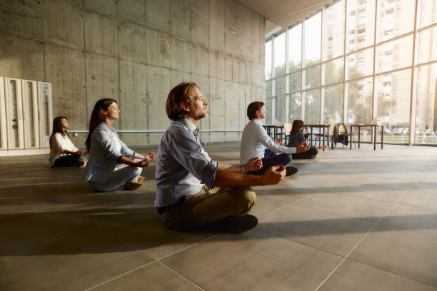 relaxed entrepreneurs meditating on the floor in the office. - yoga meditating business group of people imagens e fotografias de stock