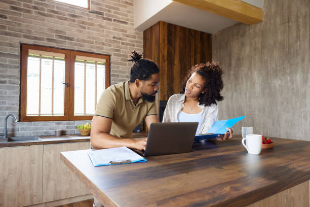 istock Young black couple working on documents and laptop at home. 1502217480
