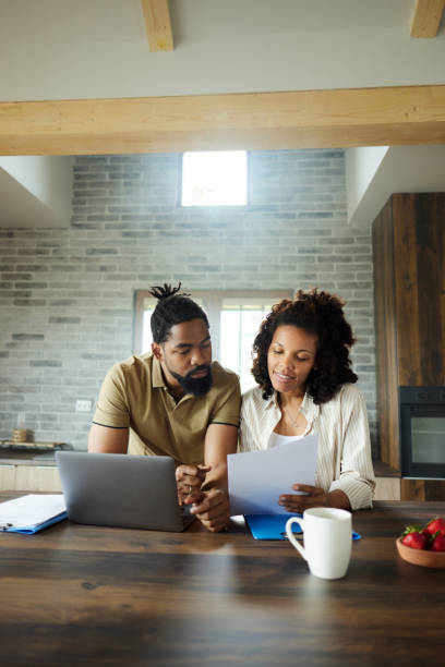 istock African American couple working on reports and computer at home. 1502217532